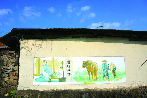 벽에 농사를 짓는 농부와 글공부중인 선비의 그림이 그려져 있는 모습