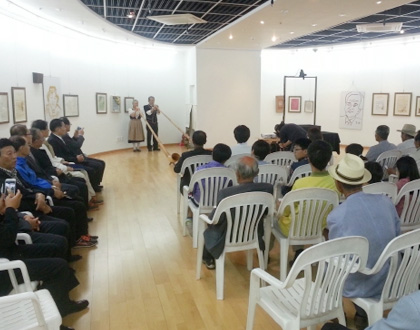 천관문학관 전시관에 관람객들이 앉아서 문학공연을 즐기고 있는 모습