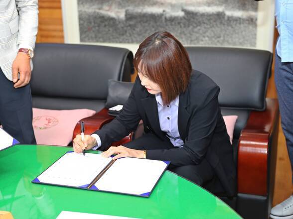 협약서에 사인중인 KDH엔터테인먼트 여성 관계자 사진(크게보기)
