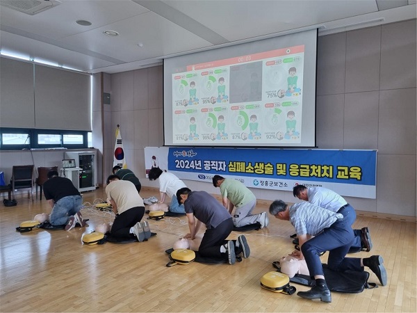 2024년 공직자 심폐소생술 및 응급처치 교욱 현수막 앞에서 심폐소생술을 시현하고있는 교육생들