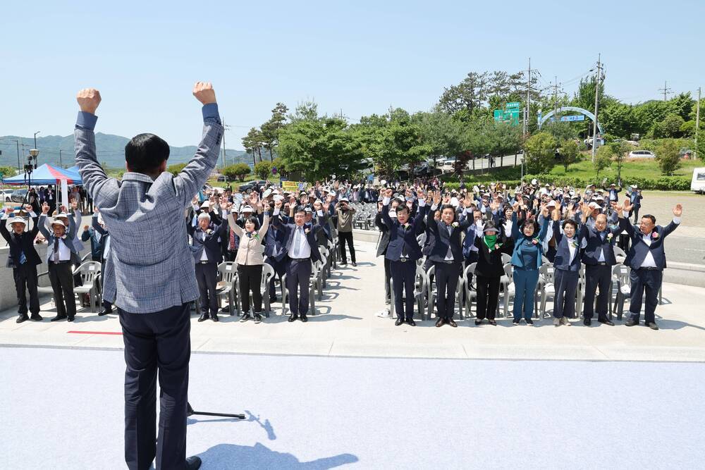 연단위에서 화이팅을 외치는 장흥군수와 앞에서 함께 화이팅포즈를 취하는 관객들 