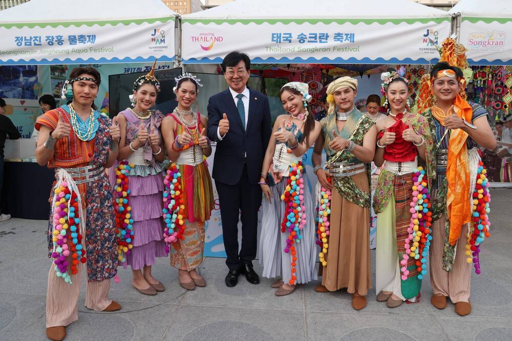 정남진 장흥 물축제, 태국 송크란 축제 현수막이 걸린 천막앞에서 축제관계자들 따봉포즈를 취하며 사진찍는 모습